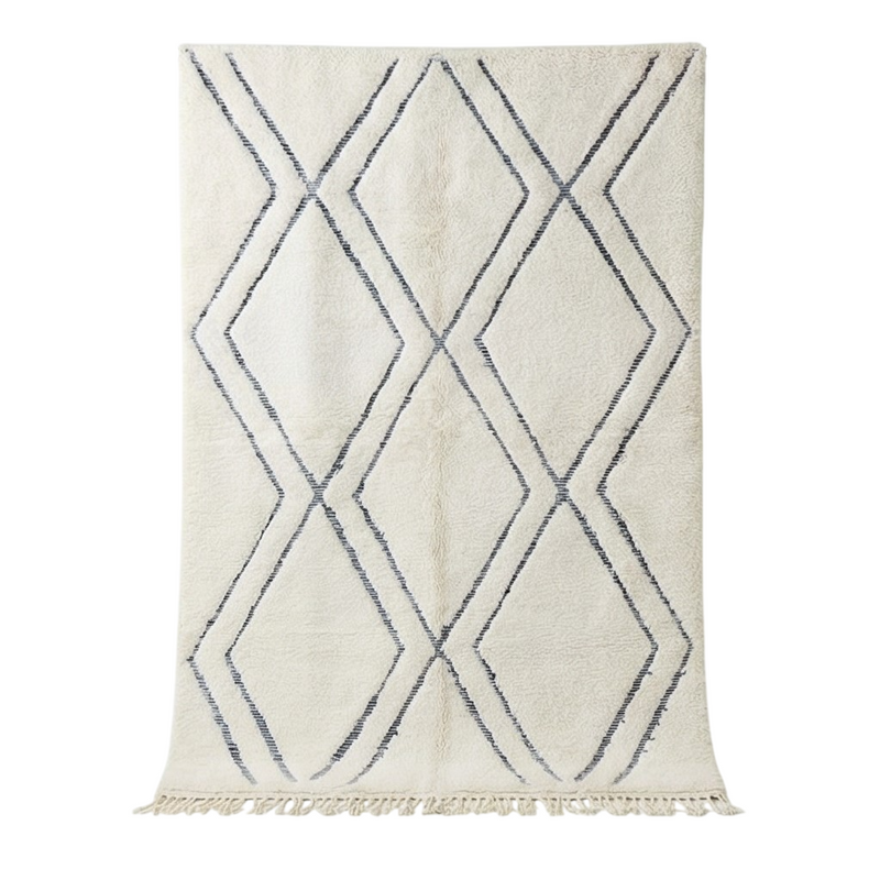 Grand tapis en relief blanc à motifs de losanges en relief avec des franges.