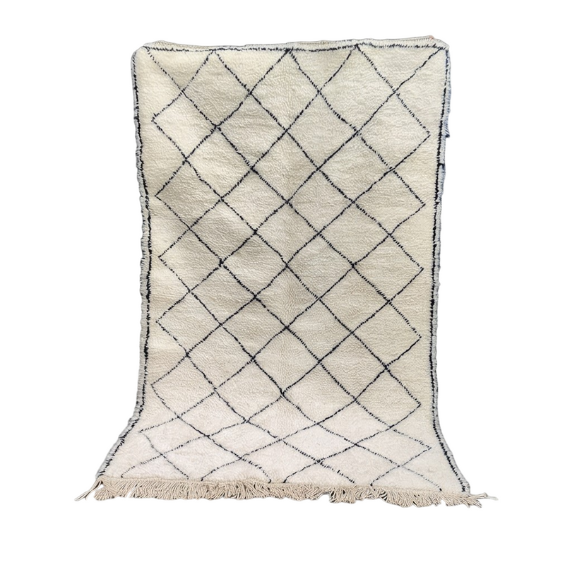 Tapis berbère blanc à motif losanges noirs de style traditionnel, avec franges décoratives.