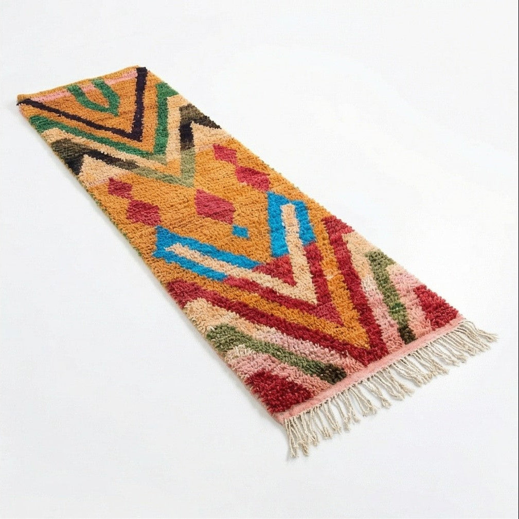 Tapis couloir berbère Boujad rouge vif avec des motifs géométriques multicolores et des franges.
