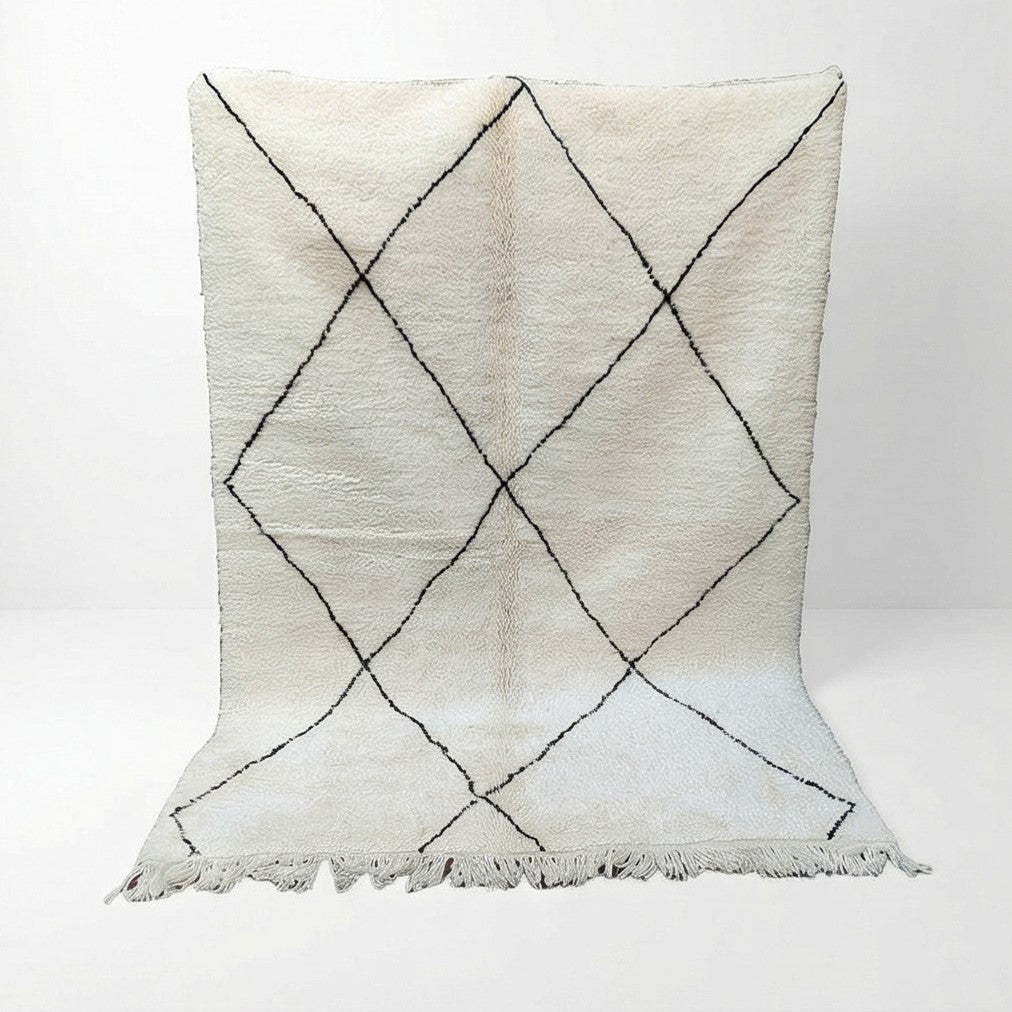 Tapis marocain blanc à losanges noirs de style berbère, avec franges.