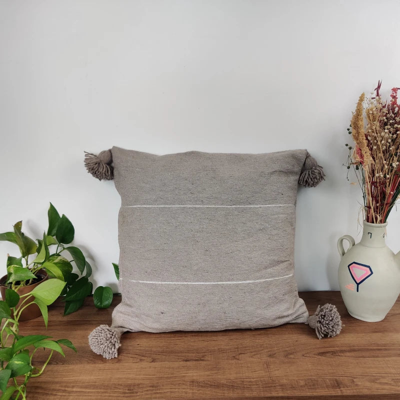 coussin à pompons gris clair
