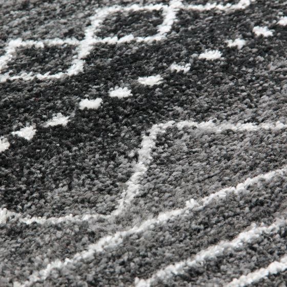 Tapis moelleux berbère marocain avec motif géométrique, parsemé de points, en gros plan.