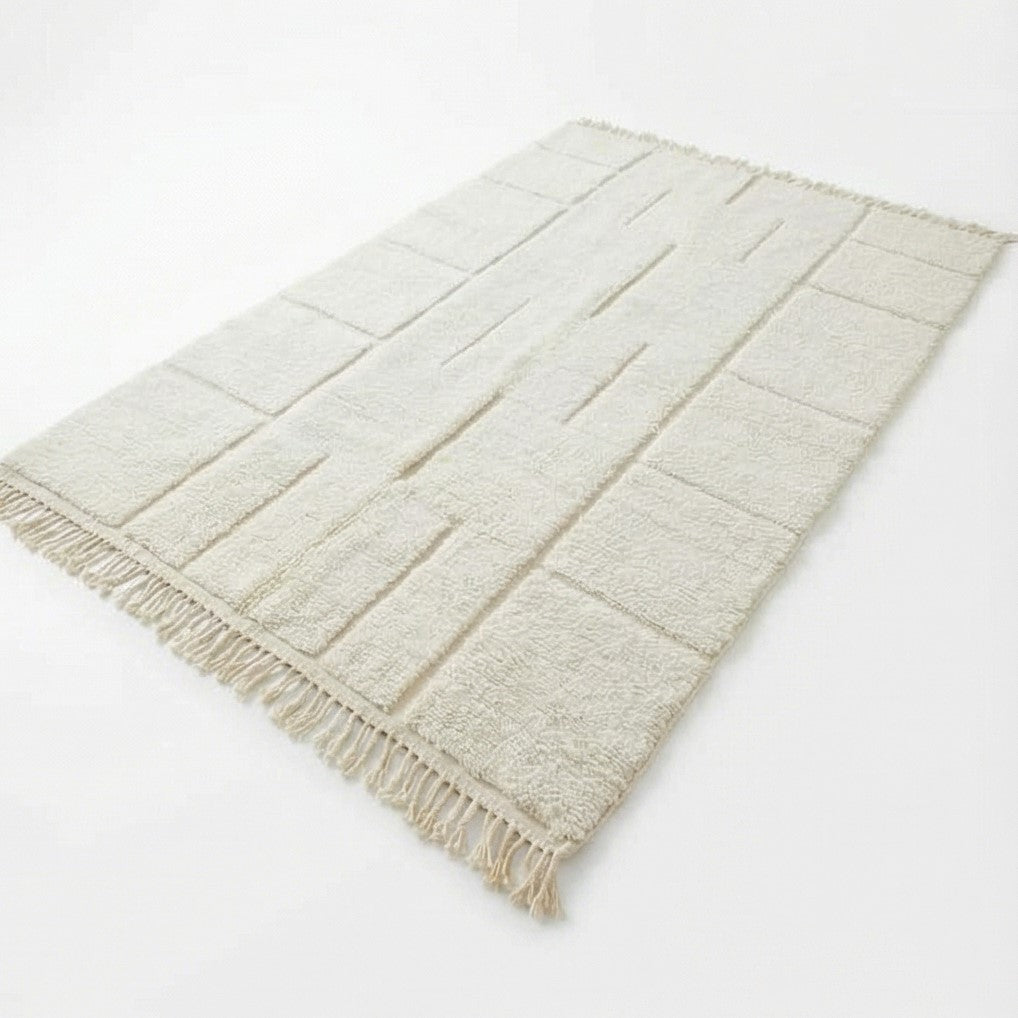 Grand tapis marocain blanc à motifs géométriques de lignes et rectangles, avec des franges décoratives.