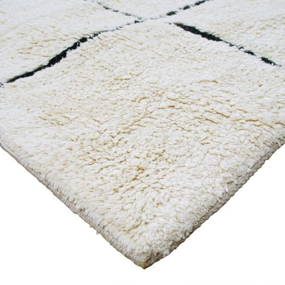 Tapis berbère quadrillé en coton, avec motif géométrique à losanges, texture épaisse et moelleuse.