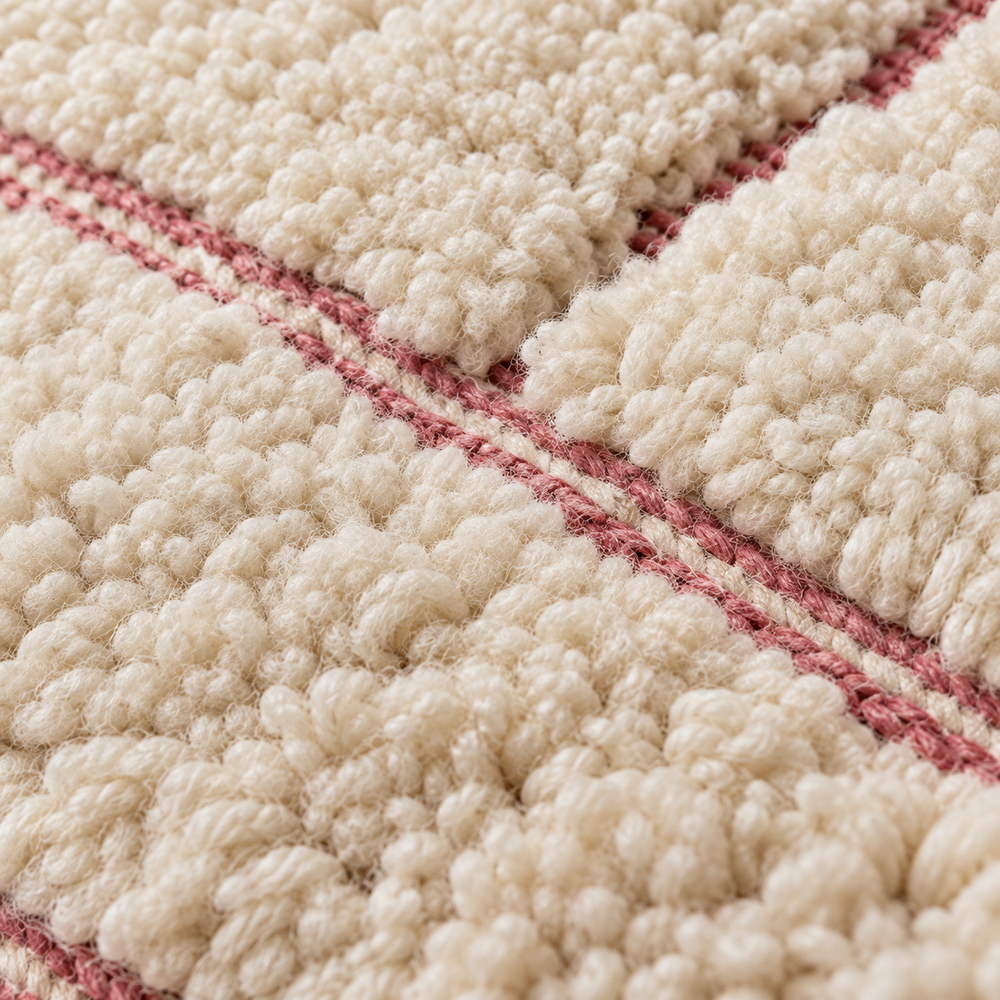Détail de la laine écrue et des lignes roses du tapis Béni Ouarain