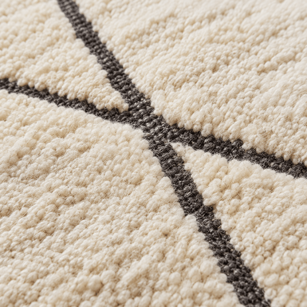 Détail de la laine écrue et des lignes noires du tapis Béni Ouarain