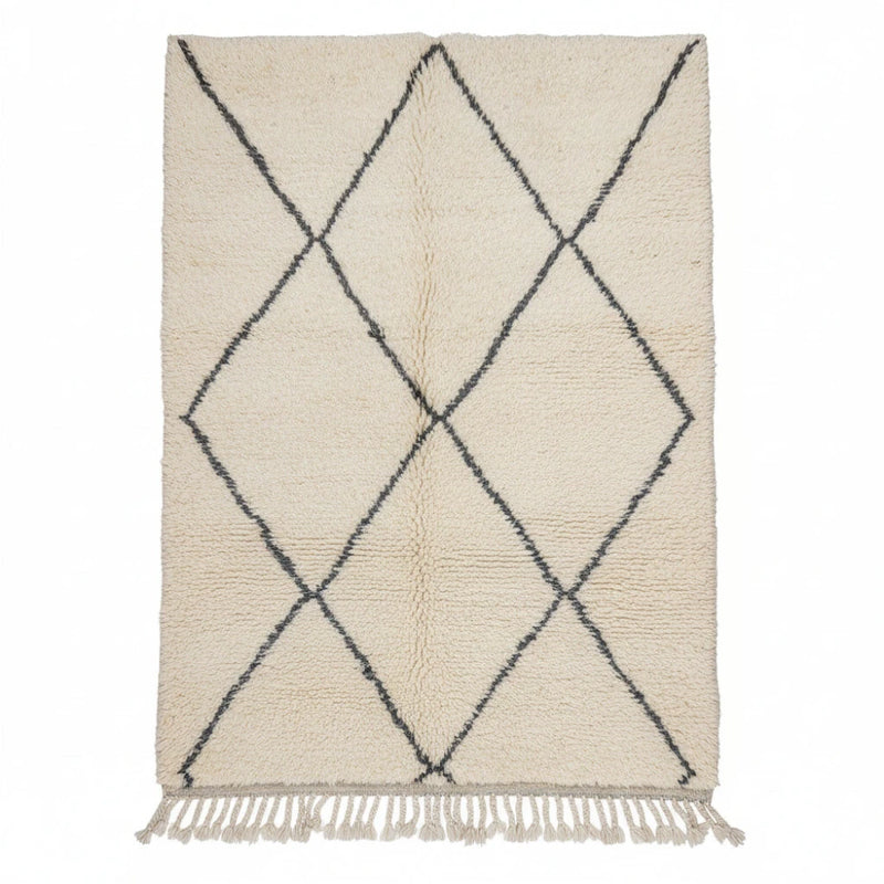 Tapis en laine écrue à losanges noirs, de style marocain, avec des franges décoratives.