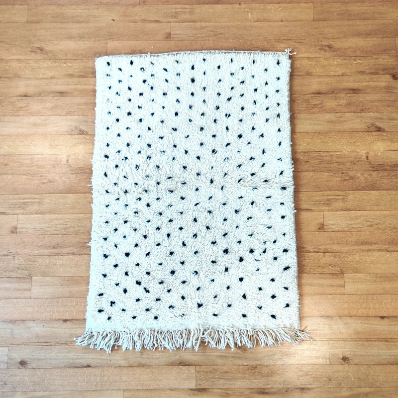 Mise en situation d'un petit tapis Beni Ouarain à pois noirs dans un cadre de vie contemporain.