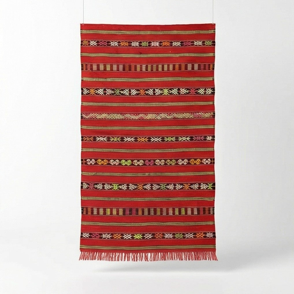 Petit tapis Kilim rouge marocain de 85x165 cm, orné de rayures horizontales et motifs géométriques traditionnels, avec des franges.