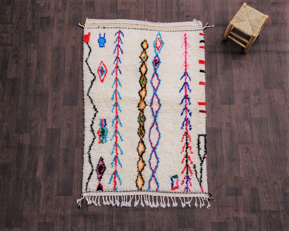 tapis berbere coloré avec un tabouret à ses côtés