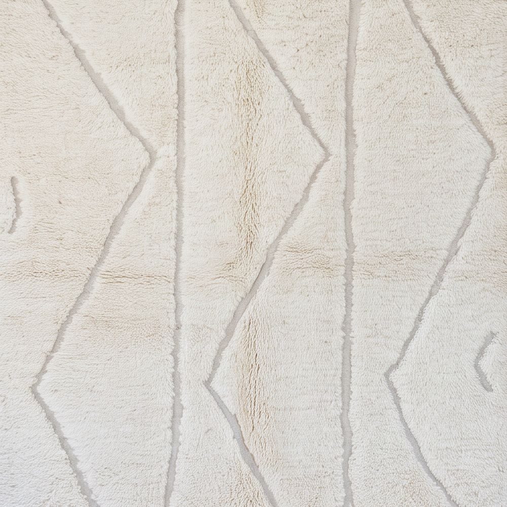 Gros plan sur la laine et le motif grands chevrons en relief ton sur ton du tapis Béni Ouarain
