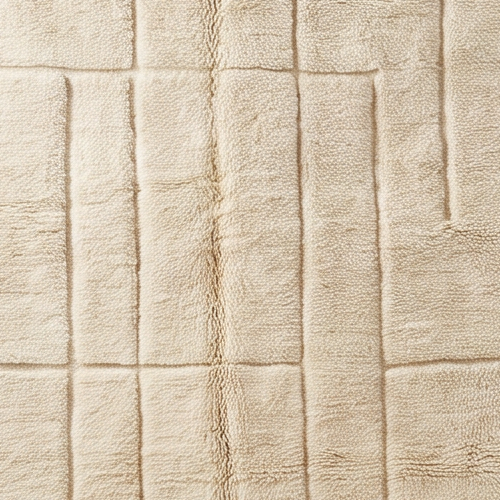 Gros plan de la laine et du motif lignes architecturales ton sur ton du tapis Béni Ouarain
