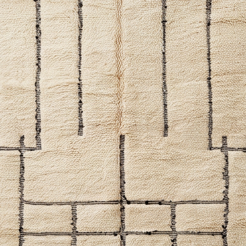 Gros plan de la laine et du motif lignes noires et grille asymétrique du tapis Béni Ouarain