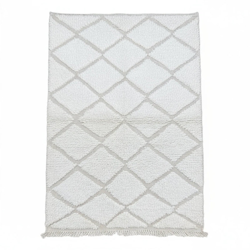 Tapis berbère blanc à losanges parsemé de motifs géométriques, avec une texture douce et des franges décoratives.