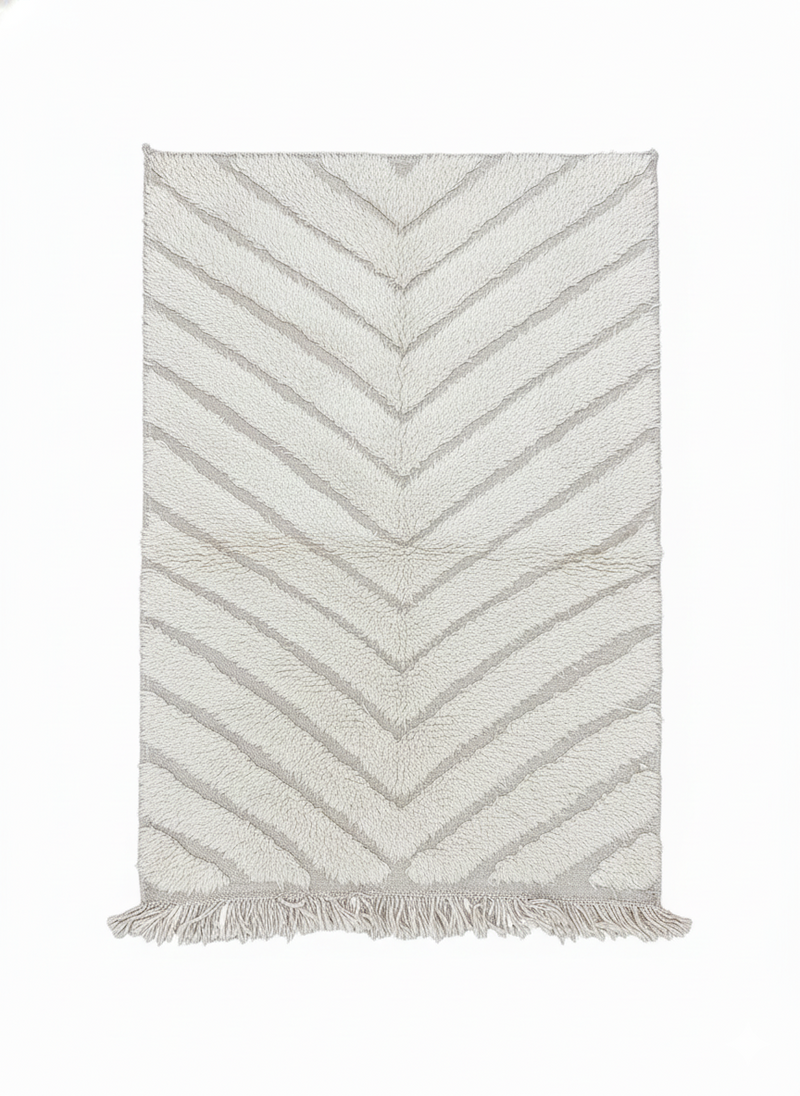 Petit tapis berbère blanc cassé à motif chevron parsemé de franges décoratives.