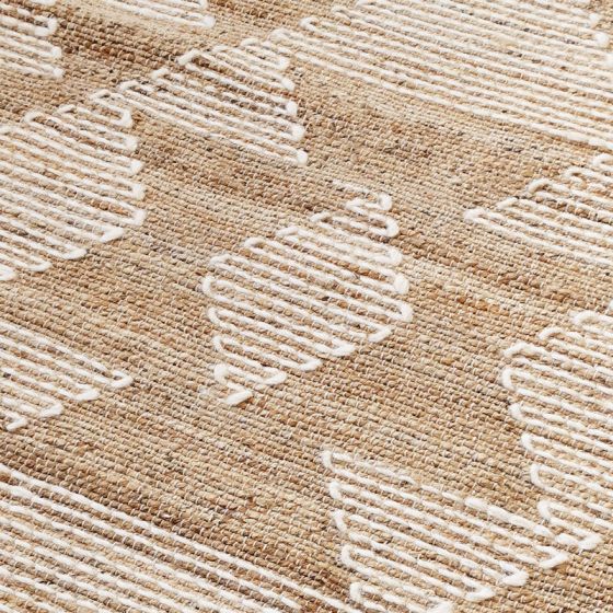 Tapis en jute ethnique à motifs berbères blancs sur fond beige texturé.