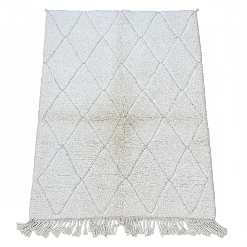 Petit tapis berbère blanc à petits losanges, avec des franges décoratives.