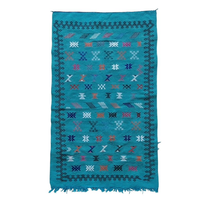 Tapis berbère turquoise en Sabra avec motifs géométriques multicolores, bordure ornementale noire et franges.