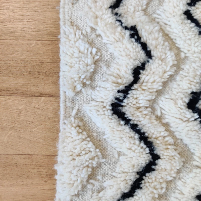 Tapis ZigZag berbère, contraste saisissant de noir et blanc, tissage artisanal marocain.
