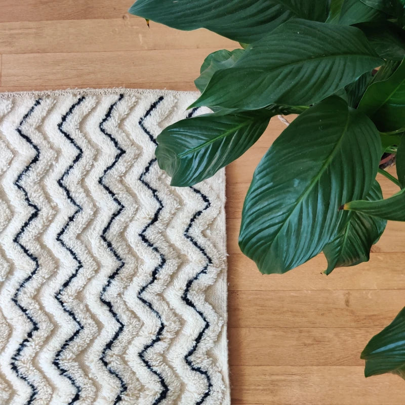 Tapis d'accent monochrome berbère avec motifs ZigZag, mélange de tradition et minimalisme.