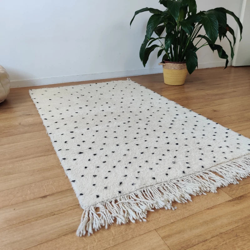 Tapis marocain traditionnel à pois noirs, parfait pour un espace cosy.