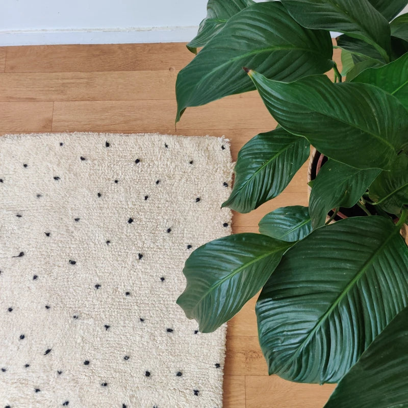 Composition berbère authentique avec pois noirs sur tapis de laine.