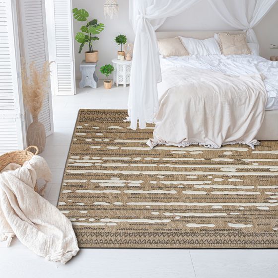 Tapis en jute naturel avec motifs géométriques en relief blancs et noirs, dans une chambre lumineuse.