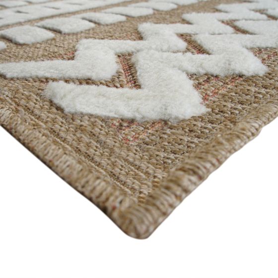 Tapis en jute beige avec motifs géométriques blancs en relief, vue rapprochée du coin.