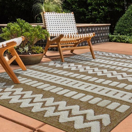 Tapis en jute beige et crème à motifs géométriques contemporains, sur une terrasse avec des chaises en bois.