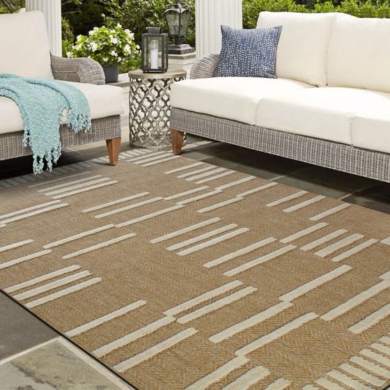 Tapis en jute beige avec motifs géométriques blancs en relief, posé sur une terrasse en pierre.