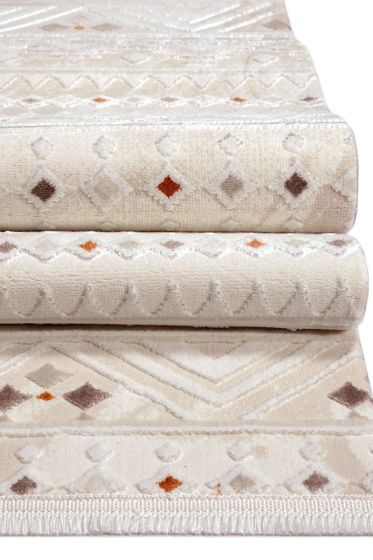 Tapis style berbère à poils ras crème avec motifs géométriques losanges et zigzags marron et orange, empilé.