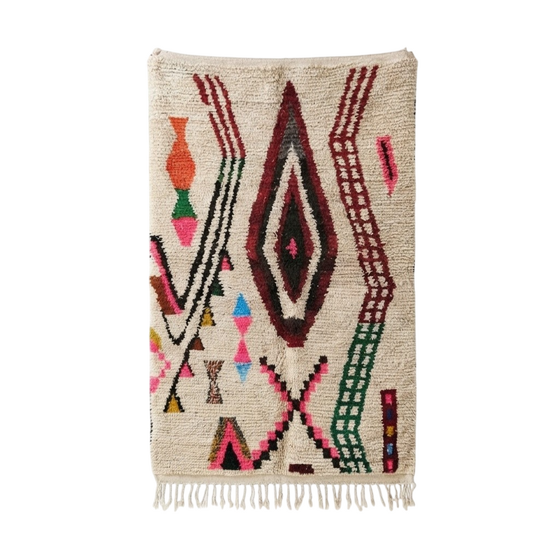 Tapis Azilal marocain coloré, crème à motifs géométriques vibrants et texture à poils longs, avec franges.