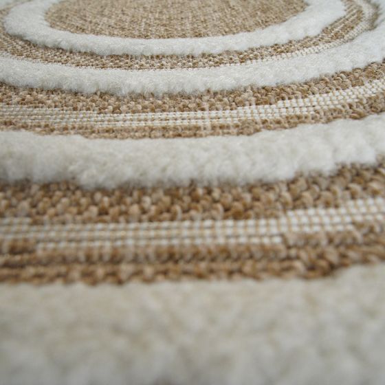 Tapis rond en jute naturel beige avec des motifs de cercles concentriques, alternant des bandes beiges tissées et des anneaux crème moelleux.