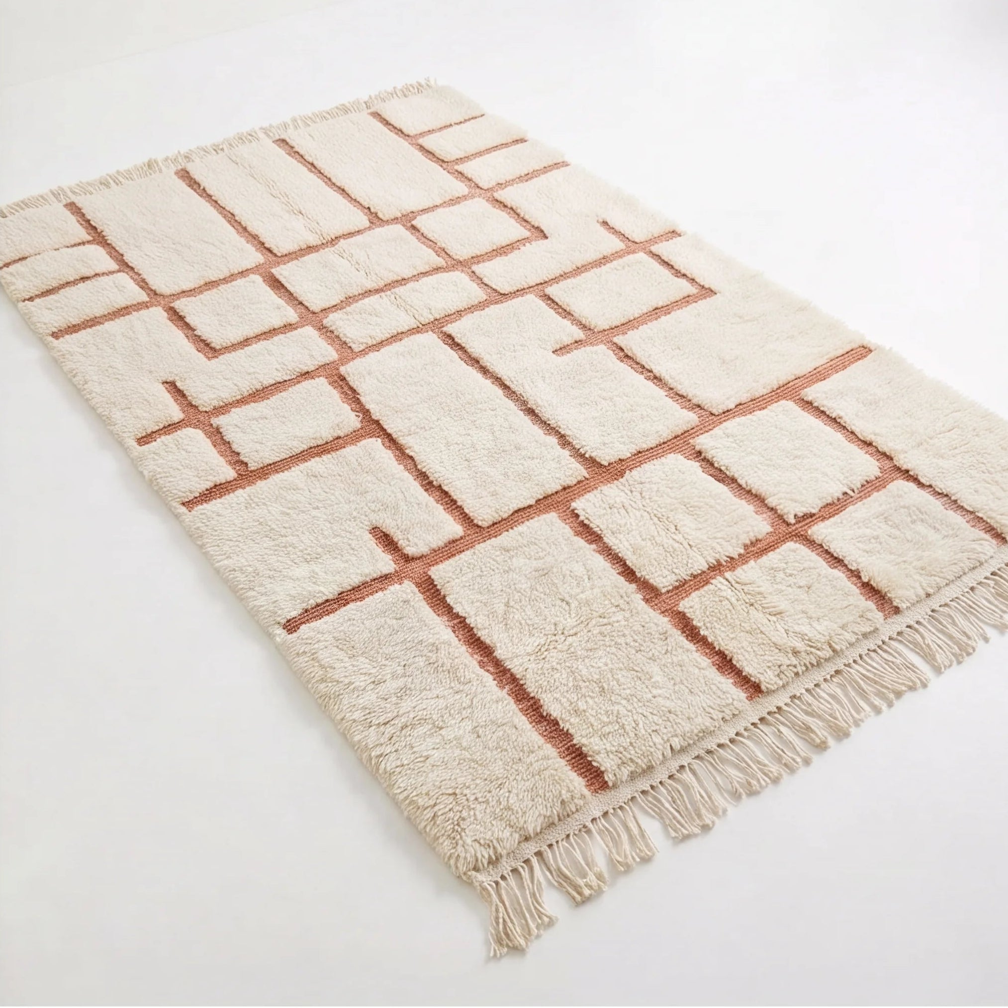 Tapis berbère écru motifs terracotta, vue de trois quarts