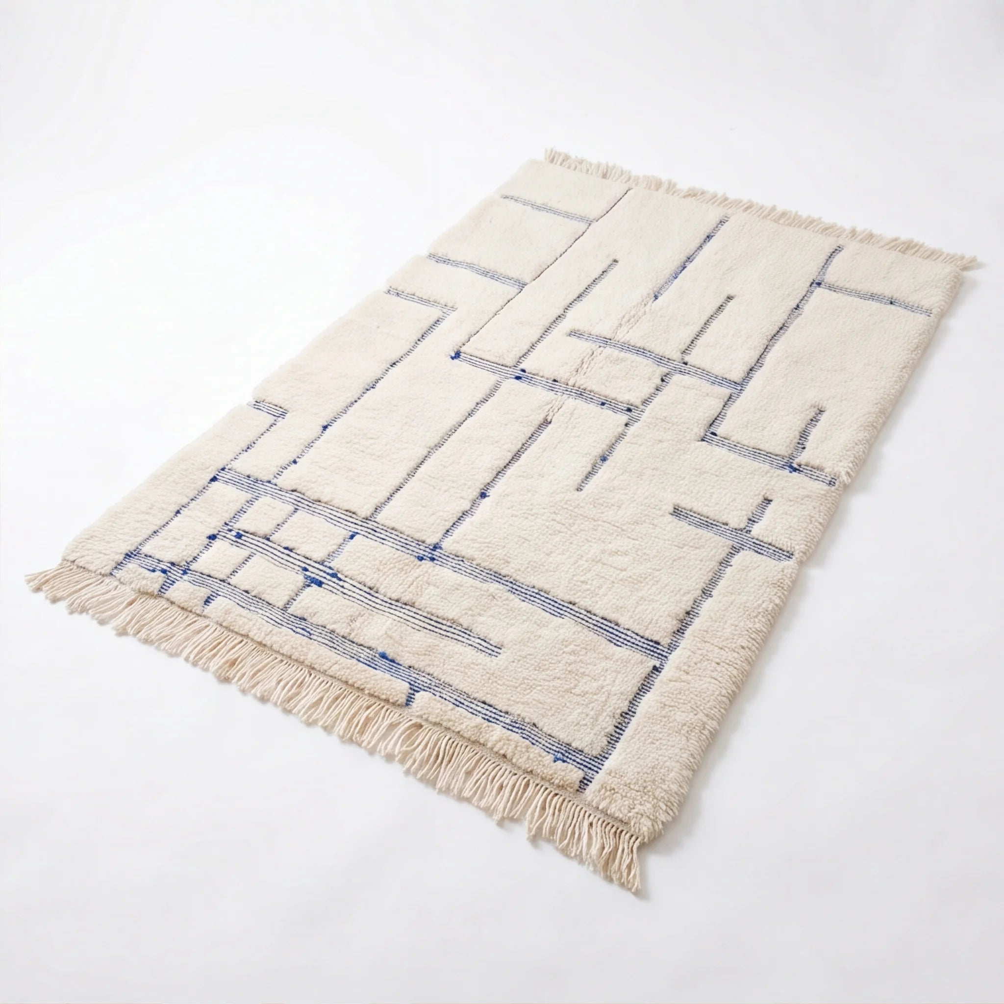 Tapis berbère écru motifs bleus, vue de trois quarts