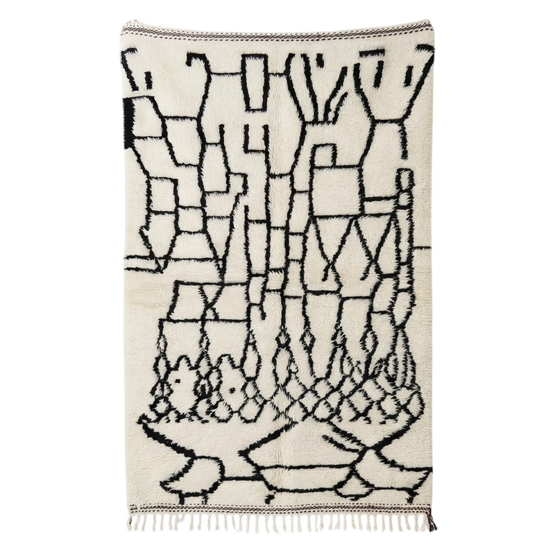 Tapis berbère blanc à motifs noirs de style Azilal, avec franges décoratives en bas.
