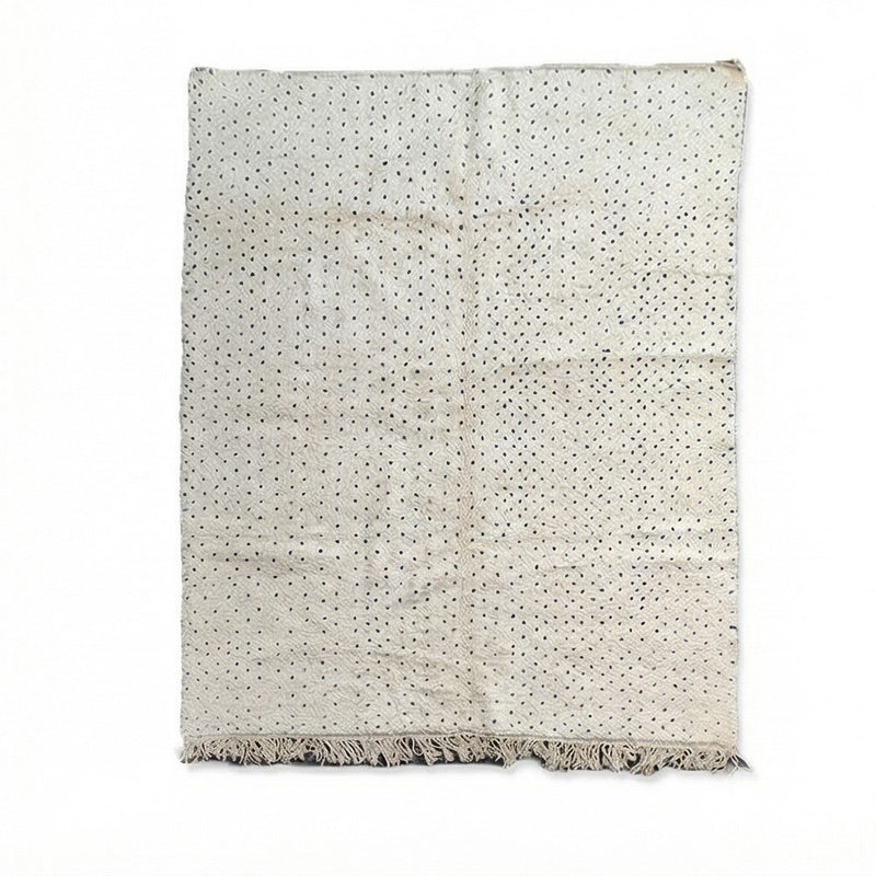 Grand tapis berbère blanc à pois bleus, avec des franges sur le bas.