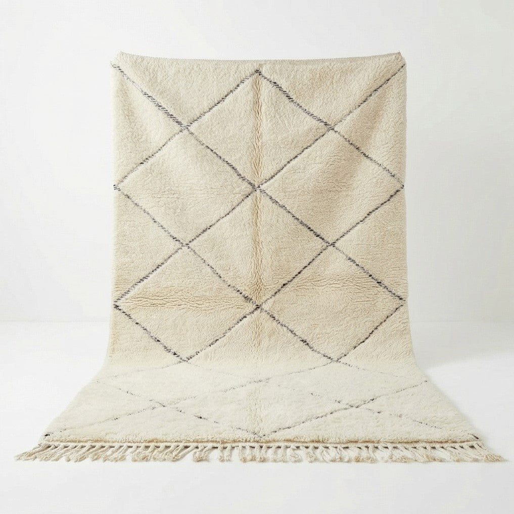 Tapis berbère blanc classique paré de losanges foncés et franges décoratives.
