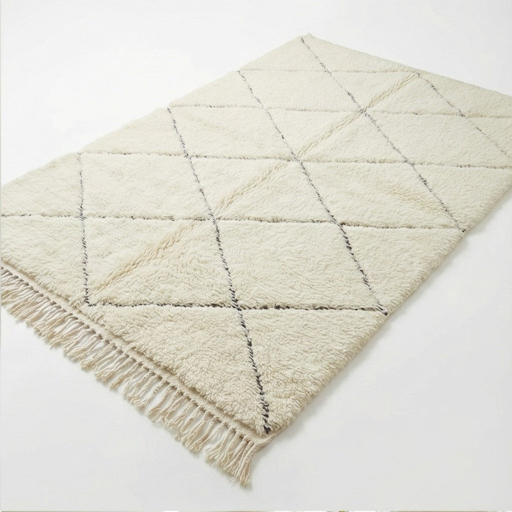 Tapis berbère blanc classique, à motif losanges noirs et franges décoratives.