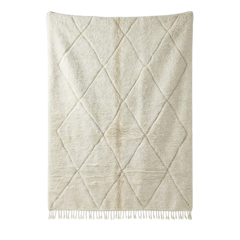 Grand tapis marocain blanc à motif de losanges parsemé de franges.
