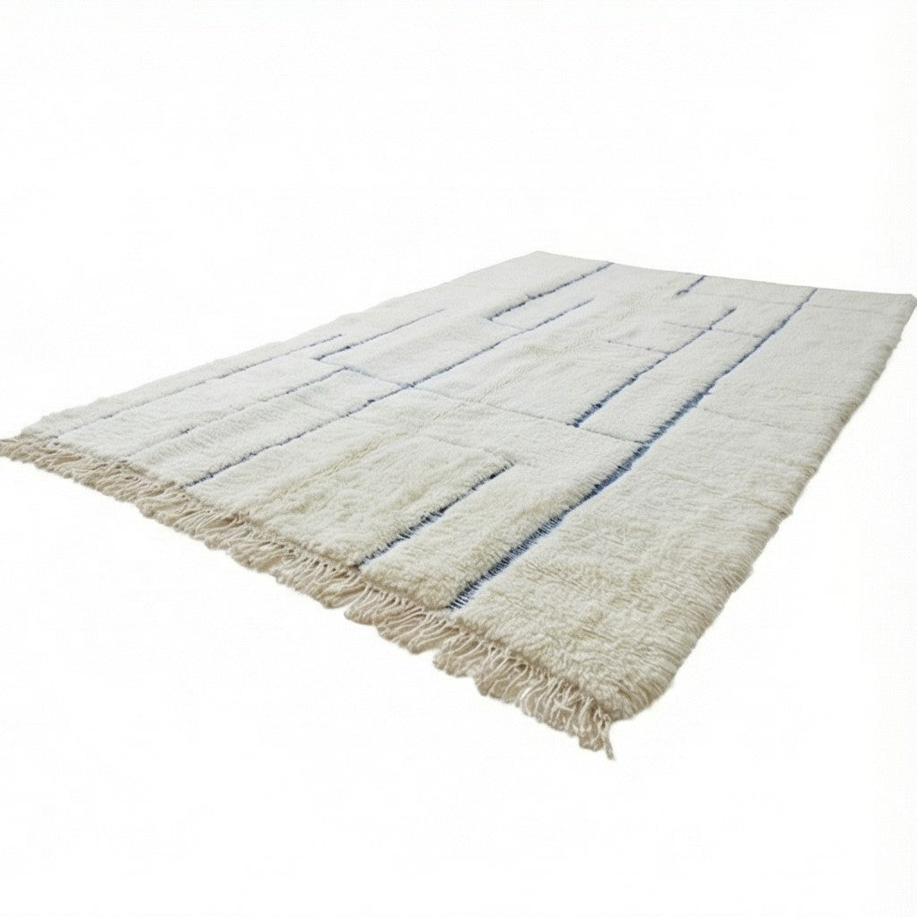Grand tapis marocain graphique blanc et bleu avec motifs géométriques, de franges décoratives.