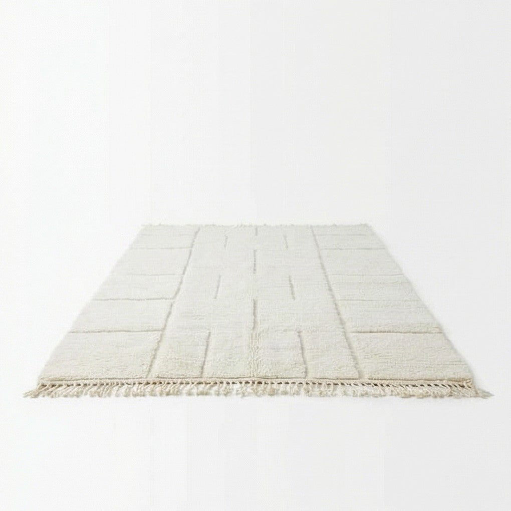 Grand tapis marocain graphique blanc de 200x300 cm, avec des motifs géométriques en relief et des franges décoratives.

