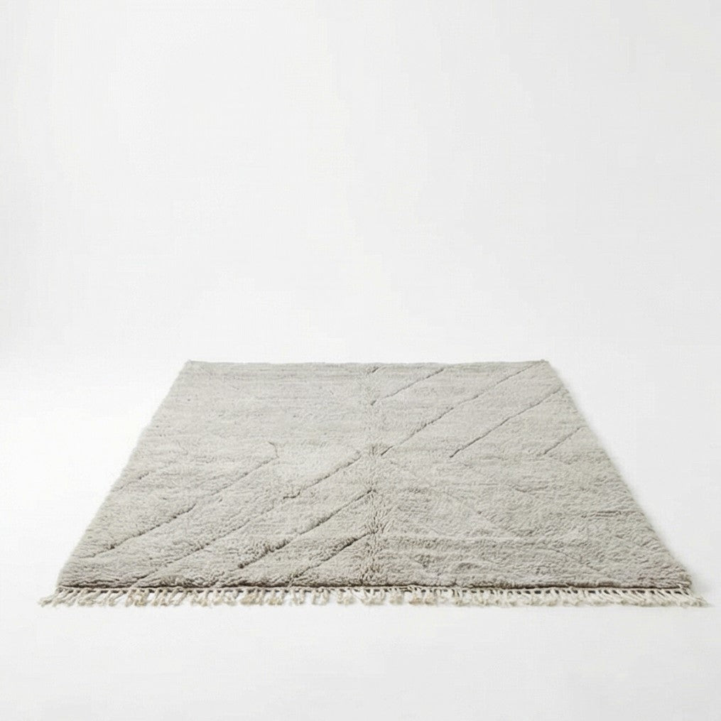 Grand tapis marocain gris en laine, motif géométrique et franges décoratives.