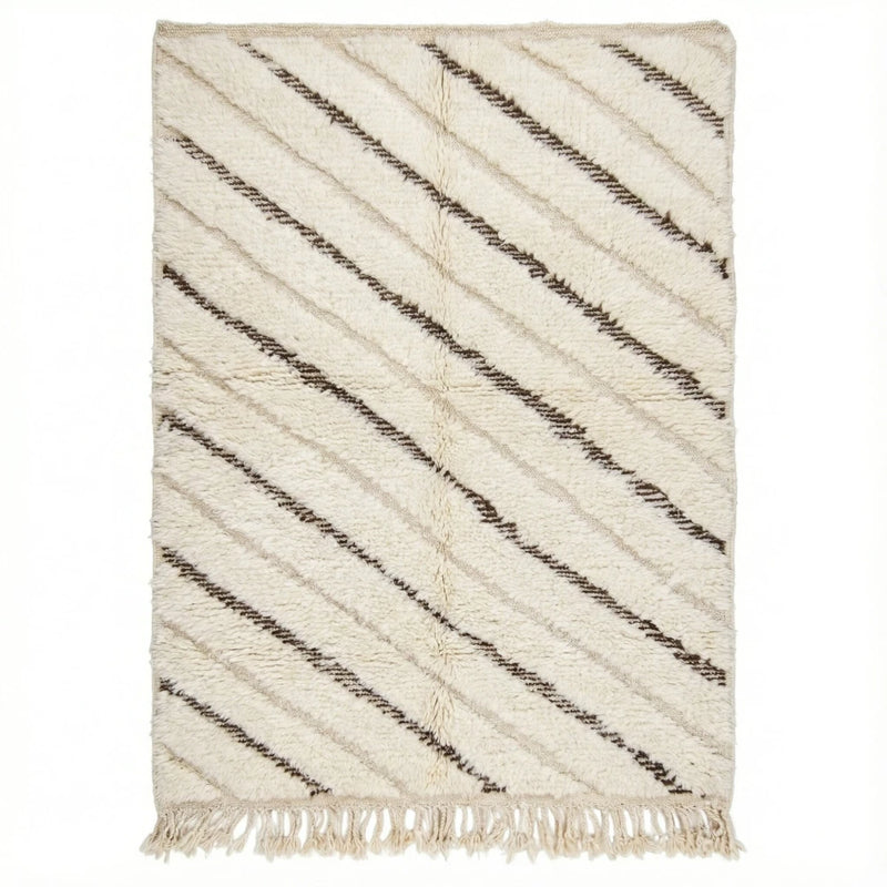 Tapis berbère graphique blanc et noir avec des rayures diagonales, orné de franges sur le bord inférieur.
