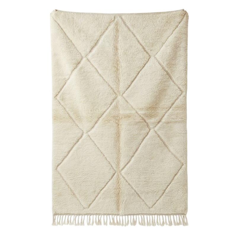 Tapis berbère blanc cassé à motif losanges, de style artisanal et franges décoratives.
