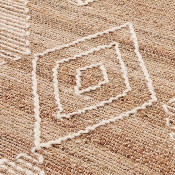 Tapis style berbère en jute naturel avec motifs géométriques blancs brodés.