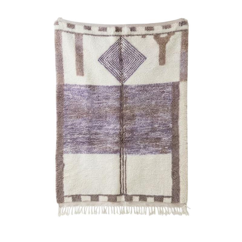 Tapis berbère en laine violet, paré de motifs géométriques et de franges décoratives.
