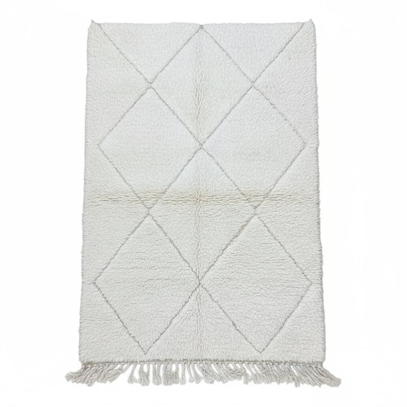 Tapis berbère blanc à losanges, agrémenté de franges décoratives.
