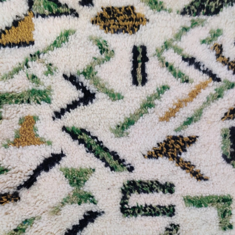 Zoom sur les motifs délicats du tapis berbère printemps vert