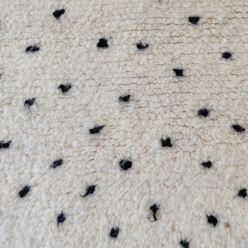 Détail du motif à pois noirs sur tapis berbère marocain.